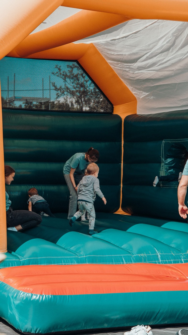 Kinder und Betreuer in einer bunten Hüpfburg bei einer Veranstaltung
