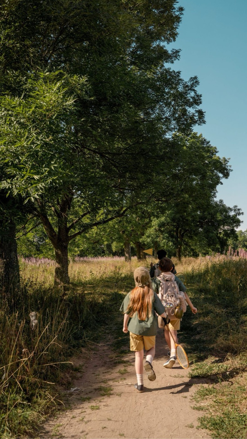 Kinder laufen auf einem Waldweg und sind gemeinsam in Bewegung